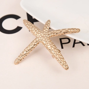 Golden starfish metal hair clip with hammer texture finish on elegant white background