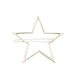 Minimalistische goldene Haarspange in Sternform aus Metall auf weißem Hintergrund