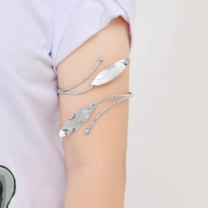 Macro detail of silver tulip armlet featuring twisted metal texture and leaf accents