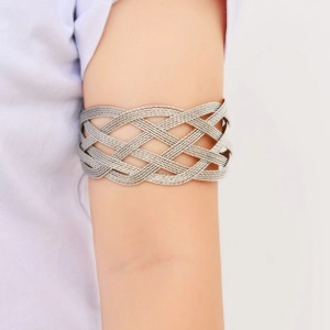 Detailed view of silver layered mesh arm cuff on model's upper arm in punk style