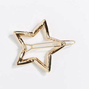 Detailopname van een gouden holle ster haarclip van legering met een gladde afwerking