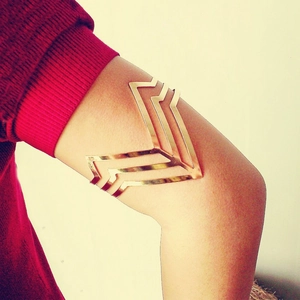 Gold-finished multi-layer geometric V-shape open arm cuff bracelet worn on upper arm
