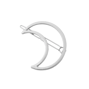 Detailed close-up of a silver crescent moon hair clip with minimalist metal finish