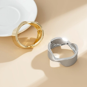 Vista dettagliata dei bracciali geometrici ondulati nelle finiture oro e argento