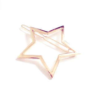 Close-up of a minimalist hollow star-shaped hair clip in polished rose gold finish