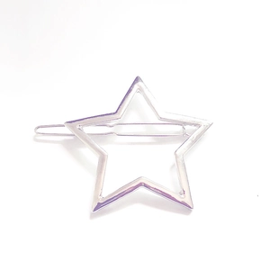 Close-up of a minimalist hollow star-shaped silver hair clip in polished metal