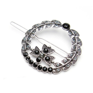 Vintage silver star round hair clip with floral textures and blue rhinestones on white background