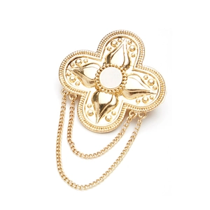 Vintage gold clover brooch with pearl inlay and dangling chains on white background