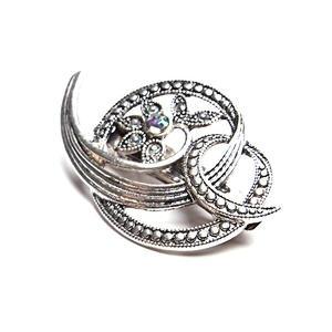 Detail view of vintage alloy floral brooch with sparkling rhinestones and iridescent stone