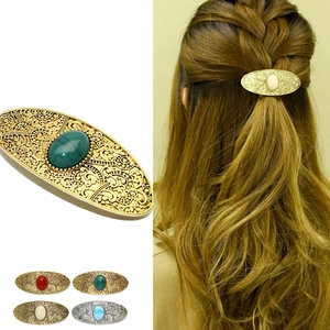 Detailed view of vintage hollow metal hair clips with large oval gemstones in multiple colors