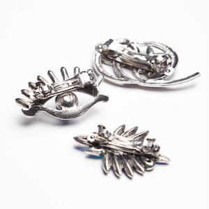 Detail view of vintage silver alloy spring clips set with Evil Eye and leaf designs