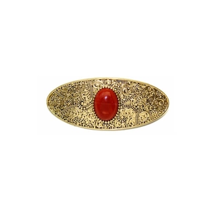 Vintage gold oval hair clip with red gemstone and embossed scroll patterns on white background