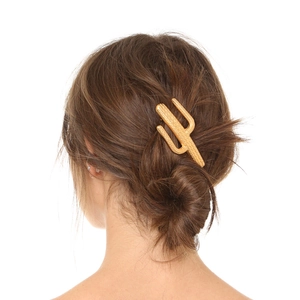 Detail view of a matte gold cactus hair clip featuring a refined textured metal finish