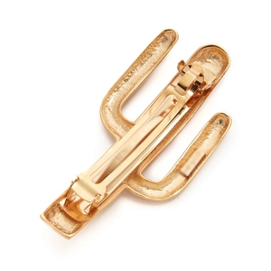 Detailed macro view of a golden cactus metal hair clip with textured surface and spring clip