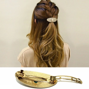 Detail view showing vintage gold alloy hair clip with vine patterns and pearl inlay