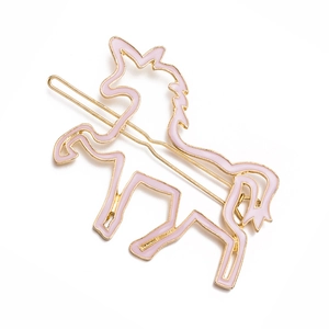 Barrette à cheveux licorne en émail rose et métal doré sur fond blanc pur
