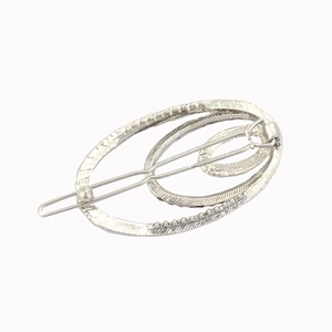 Dettaglio del fermaglio per capelli ovale geometrico argento con superficie strutturata