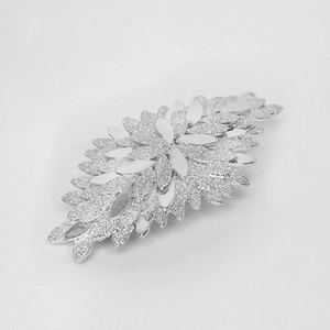 Detailed close-up of a silver leaf hair clip featuring glittery textured overlapping petals