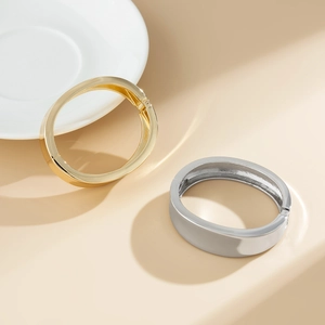 Bracciali minimalisti lucidi oro e argento con chiusura a cerniera in mostra