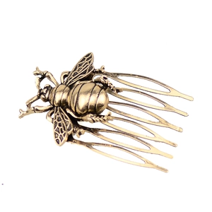 Detail of vintage bronze bee hair comb with textured wings and six-tooth metal insert