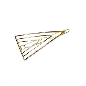 Close-up of golden geometric triangle metal hair clip with hollow minimalist design
