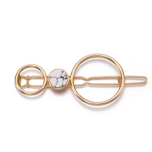 Close-up of geometric gold alloy hair clip with marble textured circular resin inlay