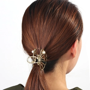 Golden alloy claw clip with pearls shown in use for a stylish hair styling hairstyle