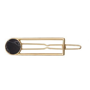 Detail of a gold rectangular hair clip featuring a black marble stone inlay decoration