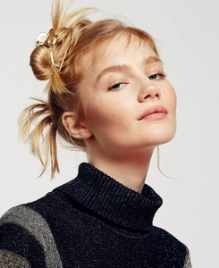 Detailed view of the large gold hollow geometric metal hair claw clip worn in hair