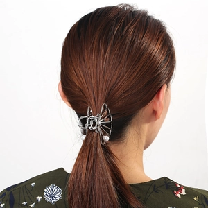 Detail of silver hollow geometric hair claw with pearls on a low ponytail style