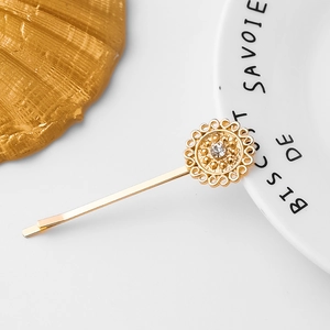 Elegant gold flower hair clip with hollow petals and a central sparkling crystal stone