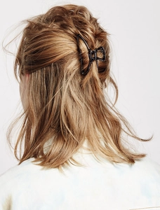 Detail view of large gunmetal geometric hair claw clip securing thick brown hair