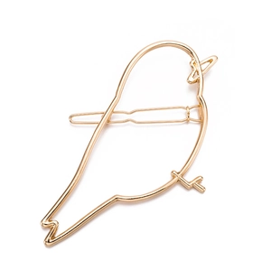 Close-up of a minimalist golden alloy bird hair clip with a polished metallic finish