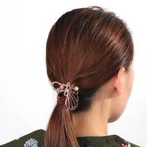 Rose gold shell claw clip with pearl detail shown on a low ponytail hairstyle