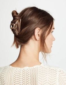 Polished gold metal hair claw clip shown in a practical back view styling on brown hair