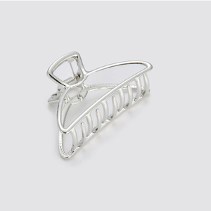 Close-up of a silver alloy hollow hair claw clip with a polished metallic finish