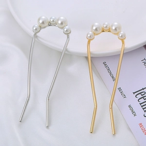 Detail of U-shaped hair pins with gold and silver metal and elegant white pearls