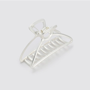 Detail view of large silver metal hair claw clip with hollow geometric design and matte finish