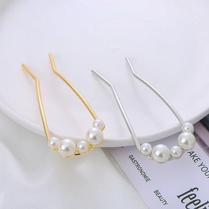 Detail view of U-shaped hair pins with elegant faux pearls in gold and silver finish