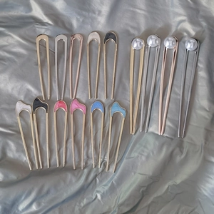 Close-up of minimalist U-shaped hairpins with enamel finishes and pearl accents
