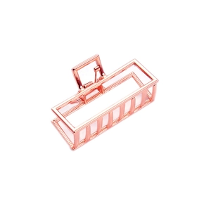 Close-up of a rose gold rectangular geometric hollow metal hair claw clip for hair styling