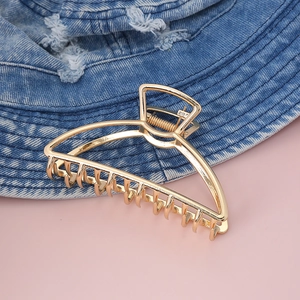 Molla per capelli in metallo dorato a doppio strato con design curvo su denim blu