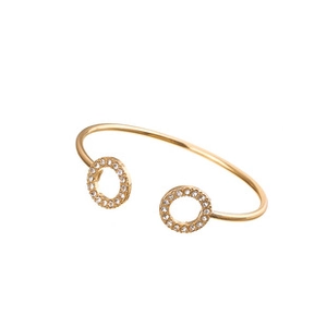 Détail d'un bracelet ouvert doré orné de deux cercles sertis de cristaux brillants