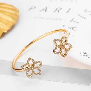 Vue détaillée du bracelet jonc doré orné de fleurs à cinq pétales serties de cristaux