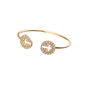 Détail d'un bracelet doré avec motifs croix ajourés sertis de zircons blancs fins