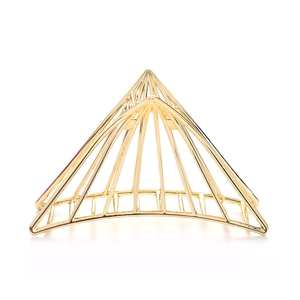 Macro detail of geometric hollow triangle metal hair claw clip in polished gold finish