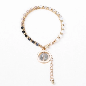 Detail of bohemian layered bracelet with colorful beads and golden ring stone pendant