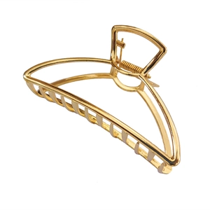Detail of large golden metal hair claw clip with strong spring and vertical grip teeth
