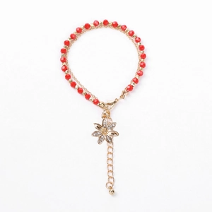 Close-up of double-layer bracelet with red crystal beads and gold flower charm