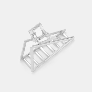 Detail view of the silver geometric hollow hair claw showing sturdy metal spring and teeth